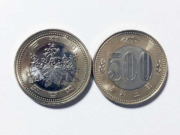 新旧500円硬貨と記念硬貨と10万円硬貨